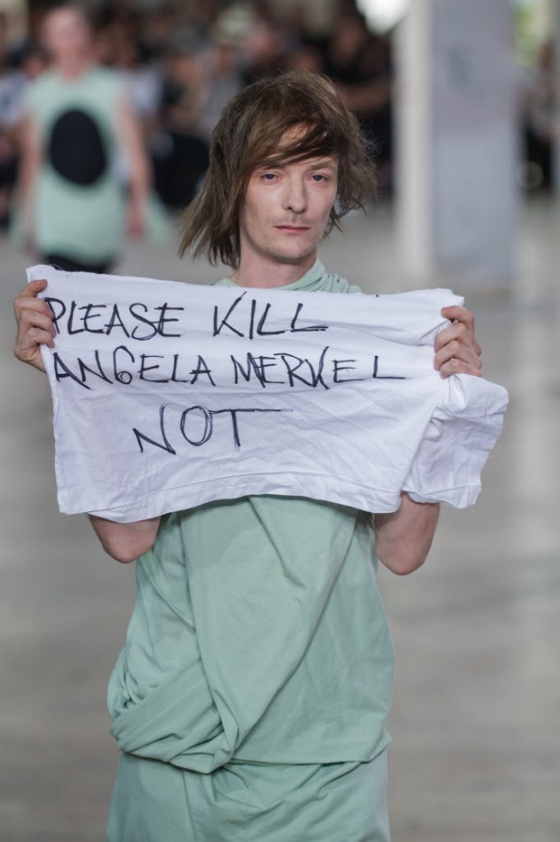 Sem avisar, modelo protesta contra Angela Merkel durante desfile do estilista Rick Owens, em Paris. Crédito:Kamil Zihnioglu/AP